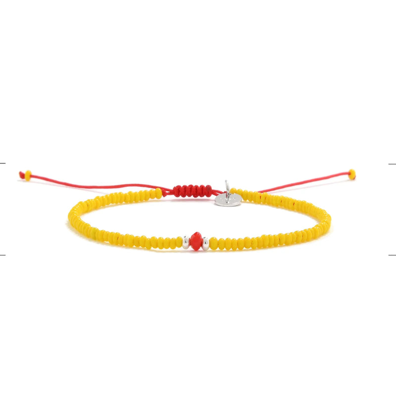 Bracelet with Glass Beads shown in full view with yellow seed beads with red glass accents and adjustable cord