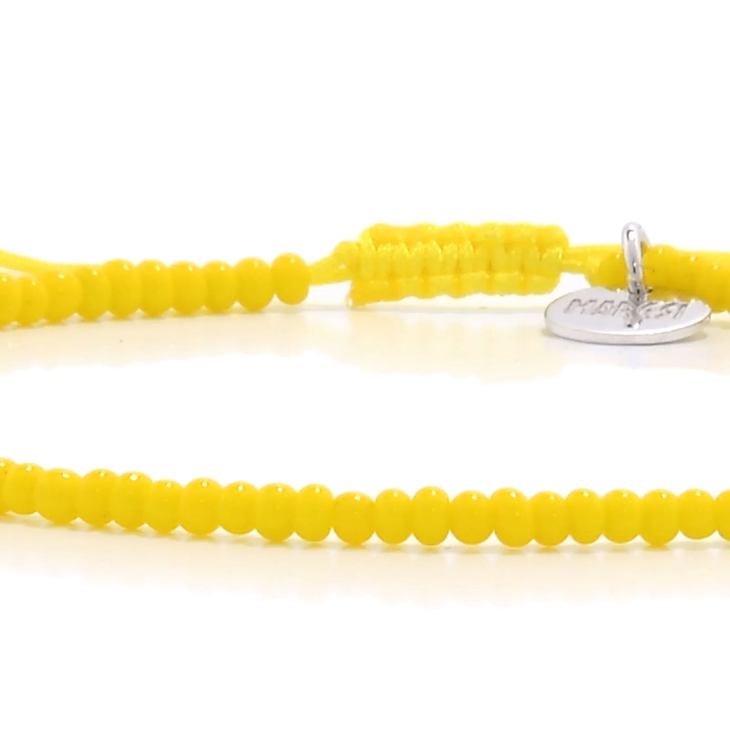 Detailed view of Bracelets Beads Essential with yellow seed beads with silver charm, seed bead texture, and cord knot