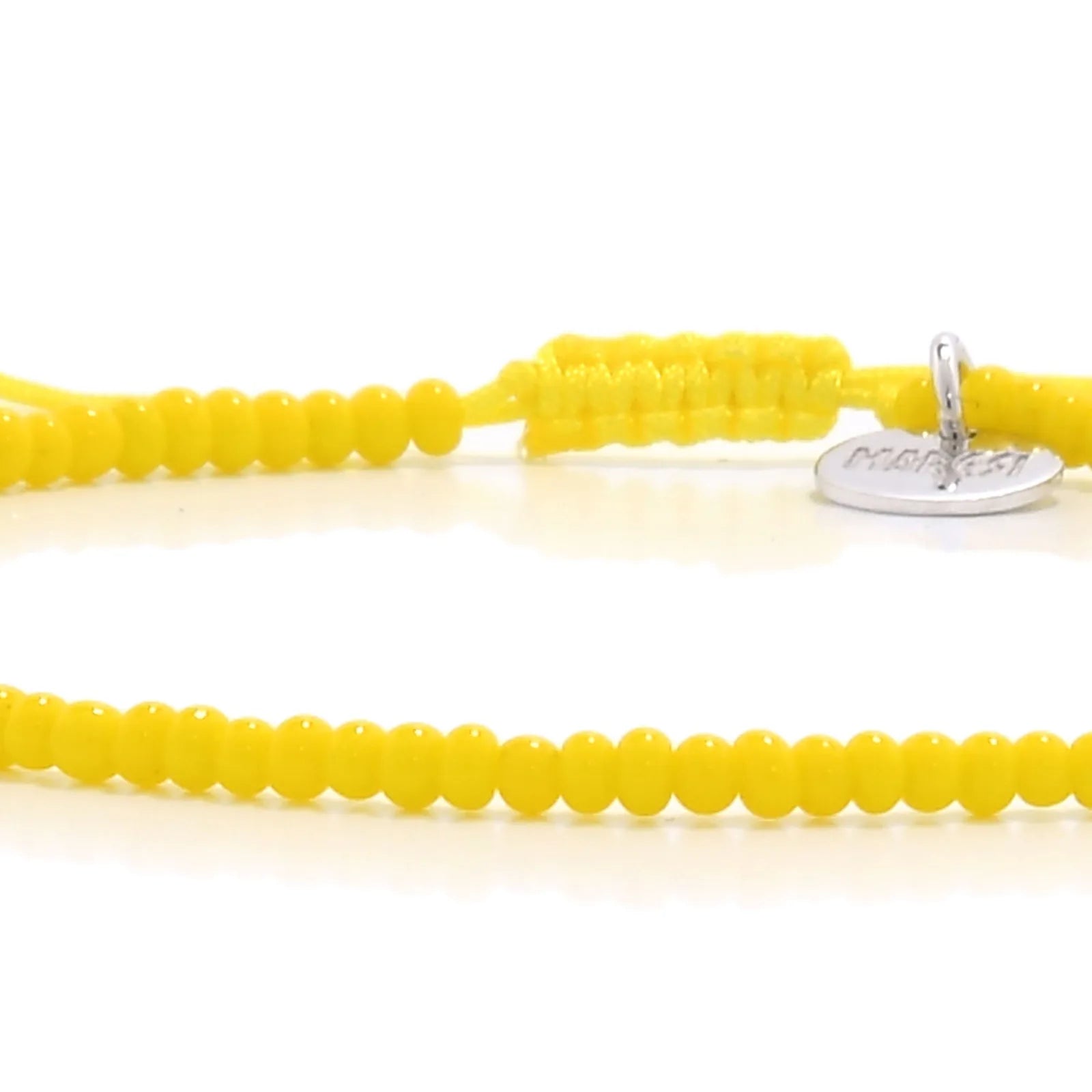 Detailed view of Bracelets Beads Essential with yellow seed beads with silver charm, seed bead texture, and cord knot