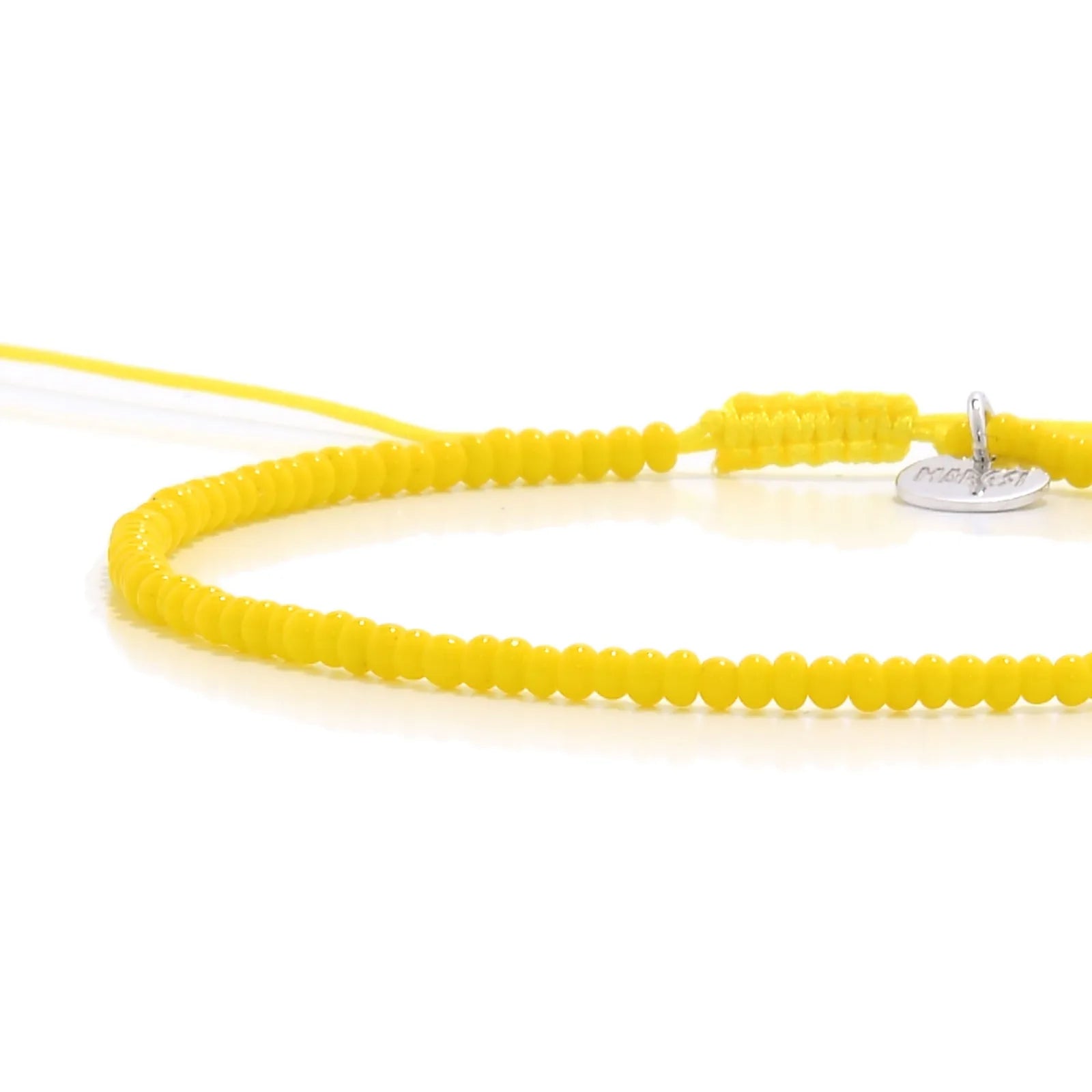 Close-up of Bracelets Beads Essential showing yellow seed beads with silver charm, silver charm, and cord closure