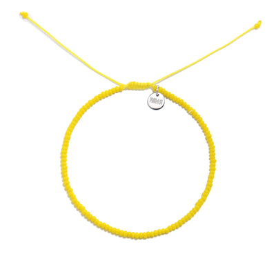 Bracelets Beads Essential shown from above with yellow seed beads with silver charm and round bracelet shape