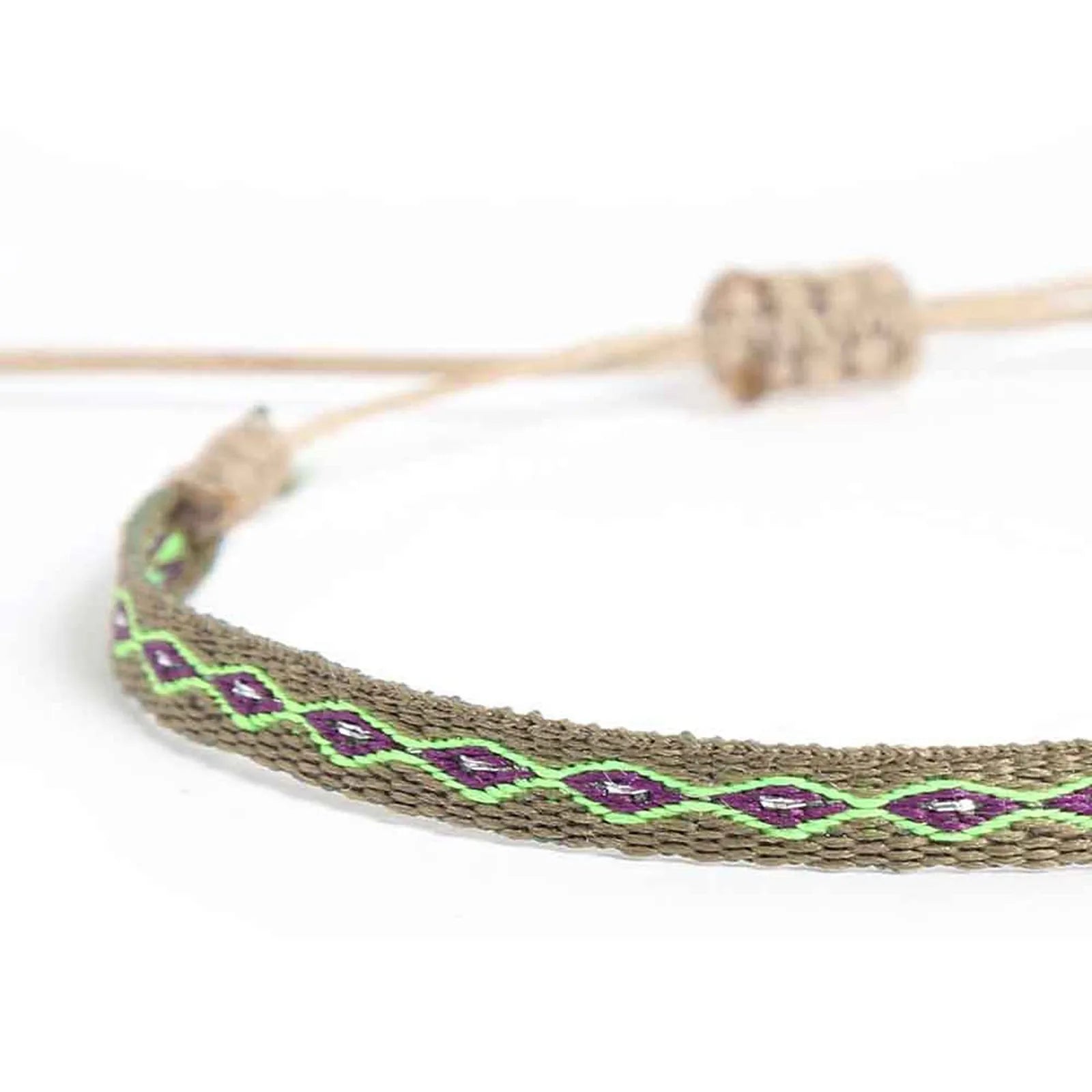Close-up of Braided Bracelet with olive woven band, purple diamonds, and bright green stitching