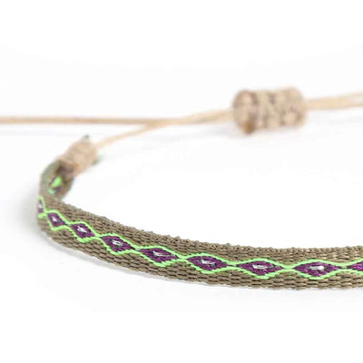 Close-up of Braided Bracelet with olive woven band, purple diamonds, and bright green stitching
