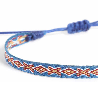 Close-up of Braided Bracelets with blue woven band, red diamonds, and cream stitching