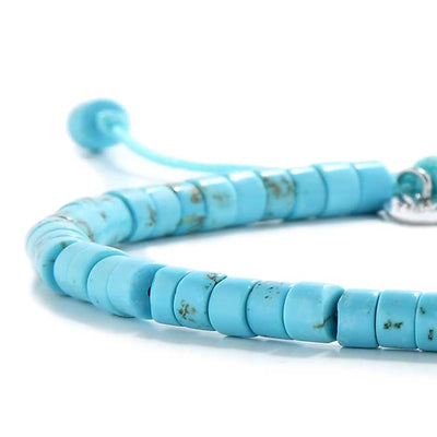 Detailed view of Clay Beads Bracelet with turquoise clay beads with silver charm, clay bead texture, and cord knot