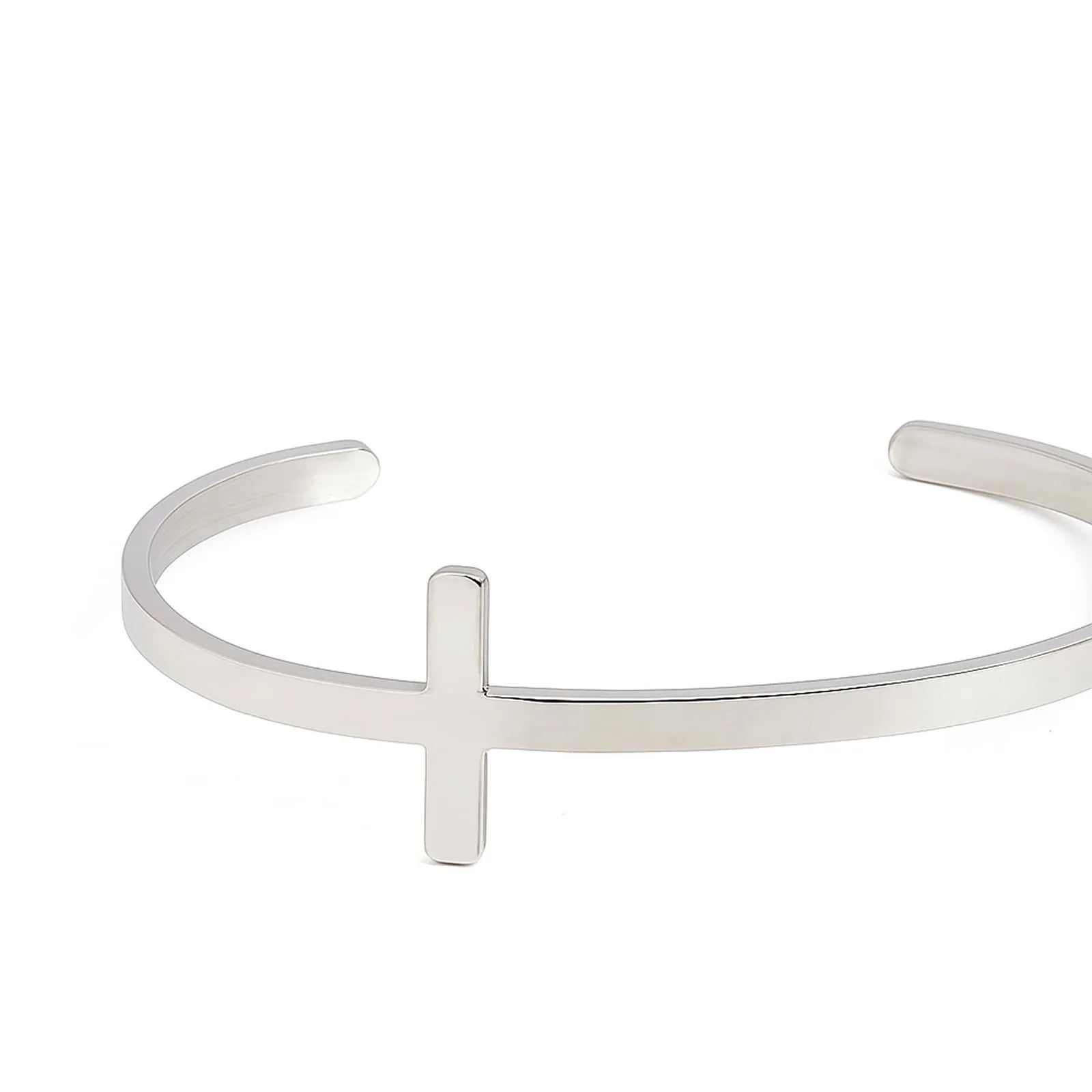 Close-up of cross bracelet showing raised cross centerpiece on a smooth polished cuff band