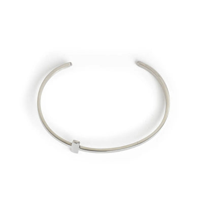 Cross bracelet shown from above with open cuff shape and raised cross centerpiece