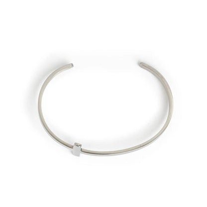 Cross bracelet shown from above with open cuff shape and raised cross centerpiece