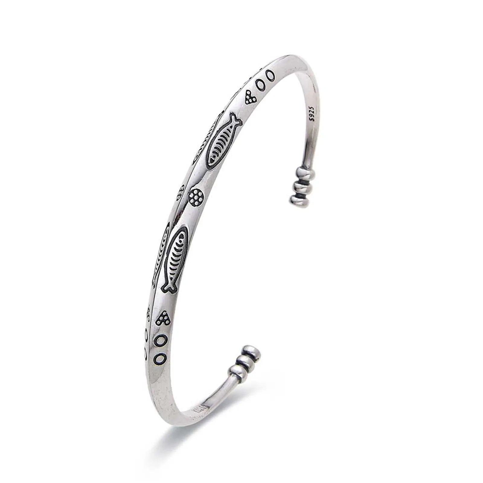 Cuff Bracelet shown in angled profile with fish engravings, dotted symbols, and rounded ends