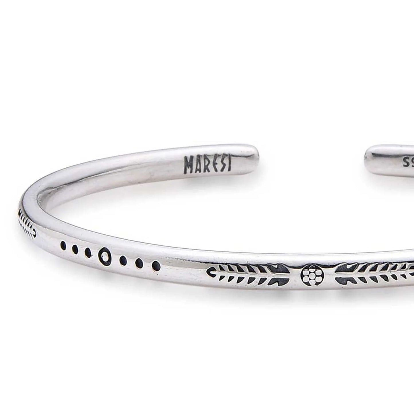 Close-up of Cuff Bracelet for Men with arrow, dot, and leaf engravings near branded end