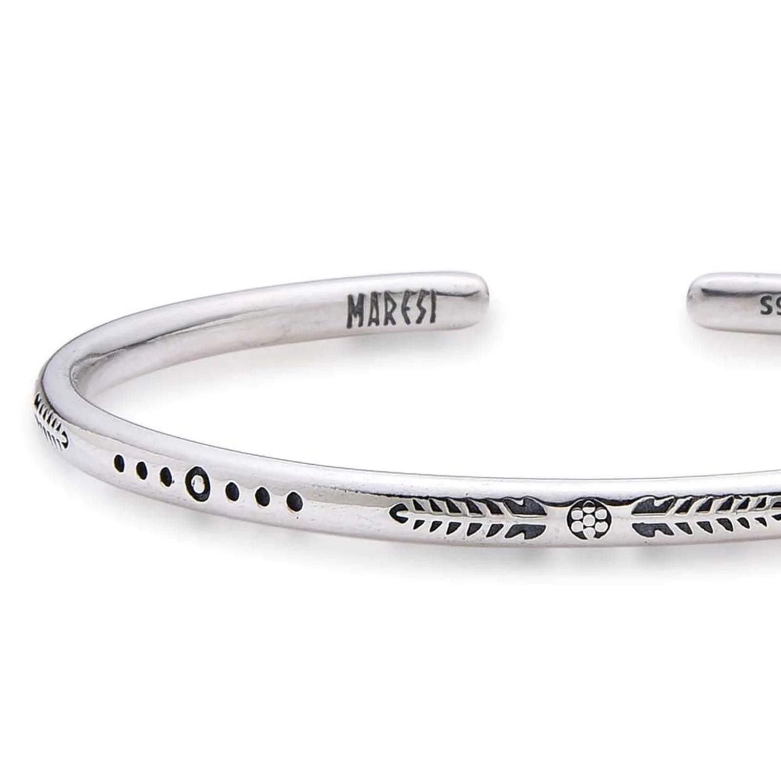 Close-up of Cuff Bracelet for Men with arrow, dot, and leaf engravings near branded end