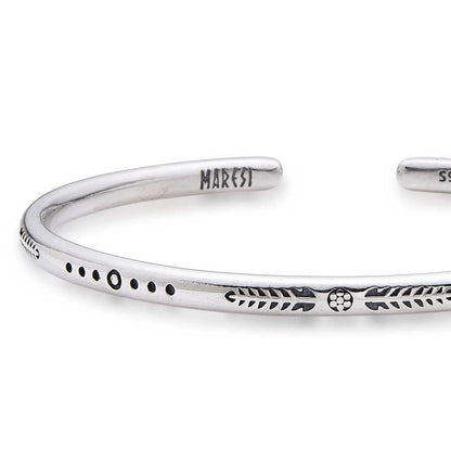 Close-up of Cuff Bracelet for Men with arrow, dot, and leaf engravings near branded end