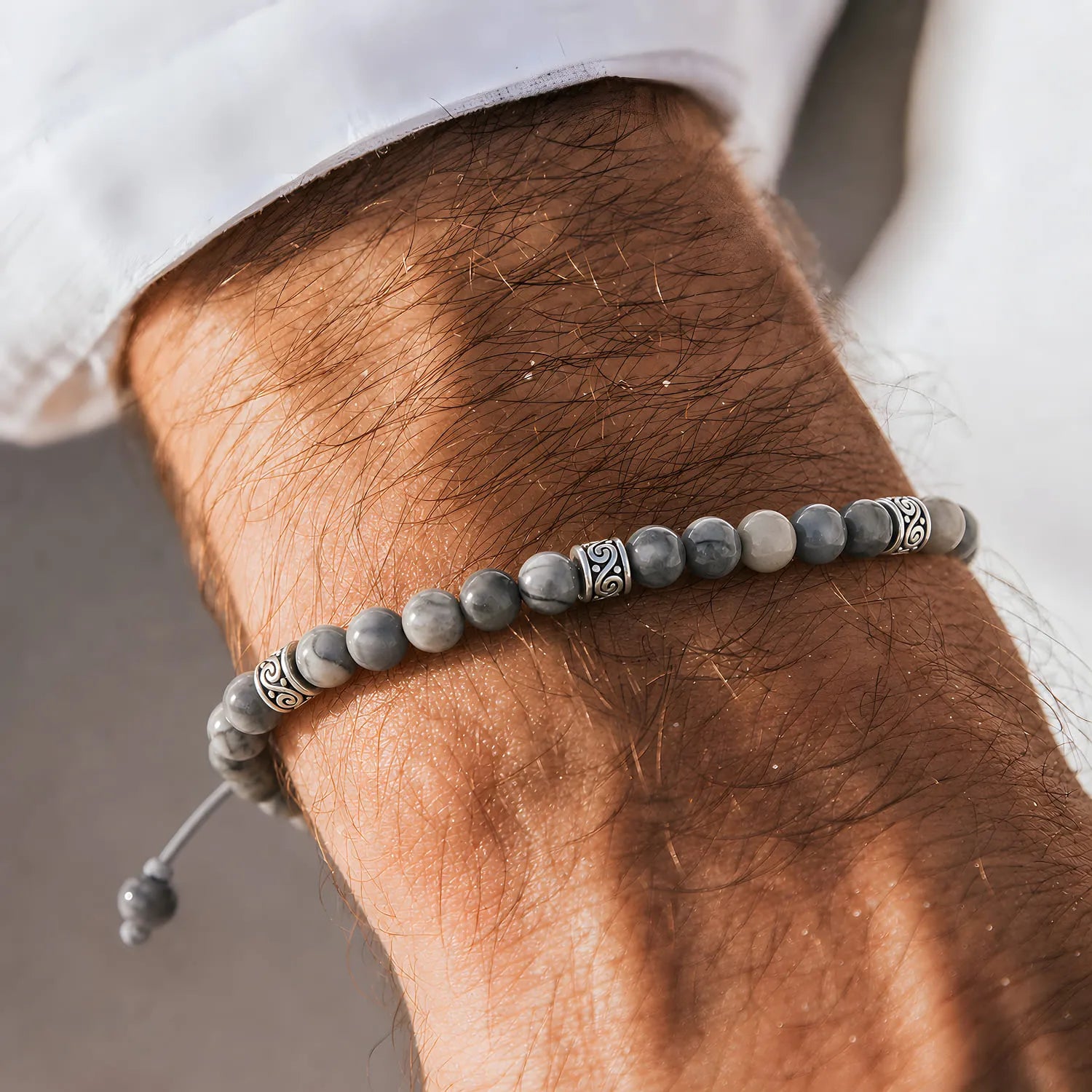 Gray Stone Bracelet worn on a wrist with beaded design and adjustable cord