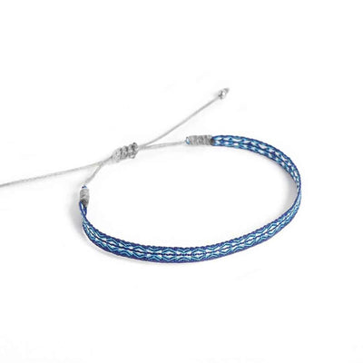 Handmade Bracelet shown from above with blue patterned band and gray sliding knot cord closure