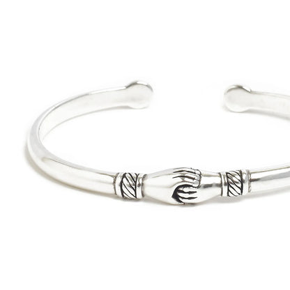 Close-up of handshake bracelet showing handshake centerpiece and carved line details
