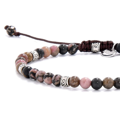 Close-up of rhodonite bracelet beads highlighting natural stone patterns and decorative metal-tone elements.
