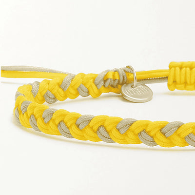 friendship bracelet thread close-up showing braided cord texture, adjustable knot, and charm detail