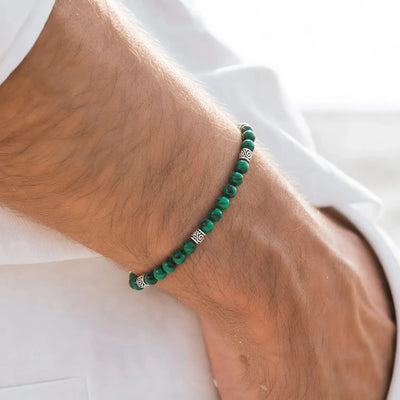 Malachite bracelet worn on wrist with stone beads and metal accents