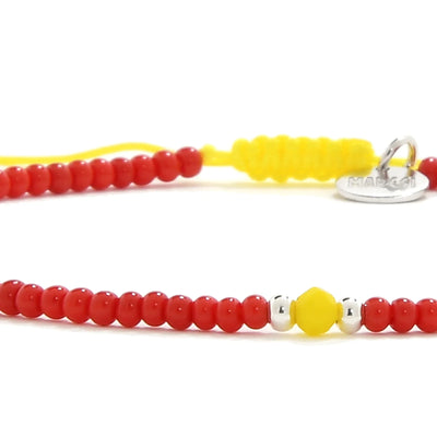 Detailed view of Man Bracelet Beads with red seed beads with yellow accent beads, seed bead texture, and cord knot