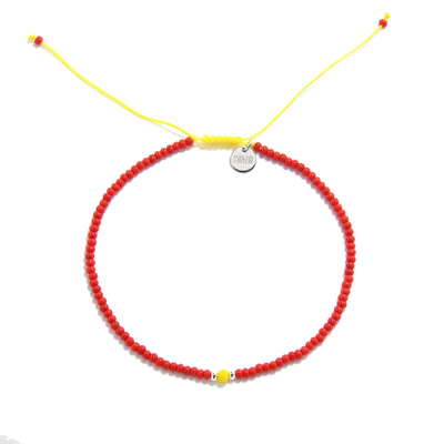 Man Bracelet Beads shown from above with red seed beads with yellow accent beads and round bracelet shape