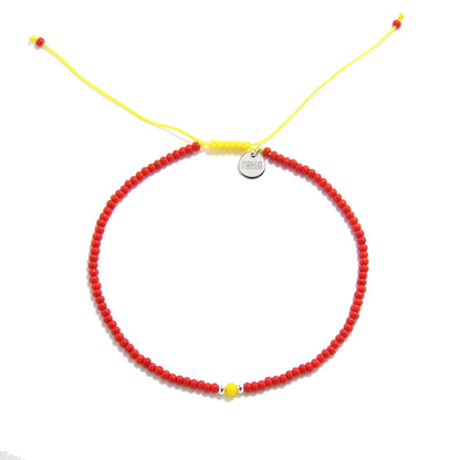 Man Bracelet Beads shown from above with red seed beads with yellow accent beads and round bracelet shape