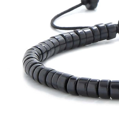 Detailed view of matte black bracelet , clay bead texture, and cord knot