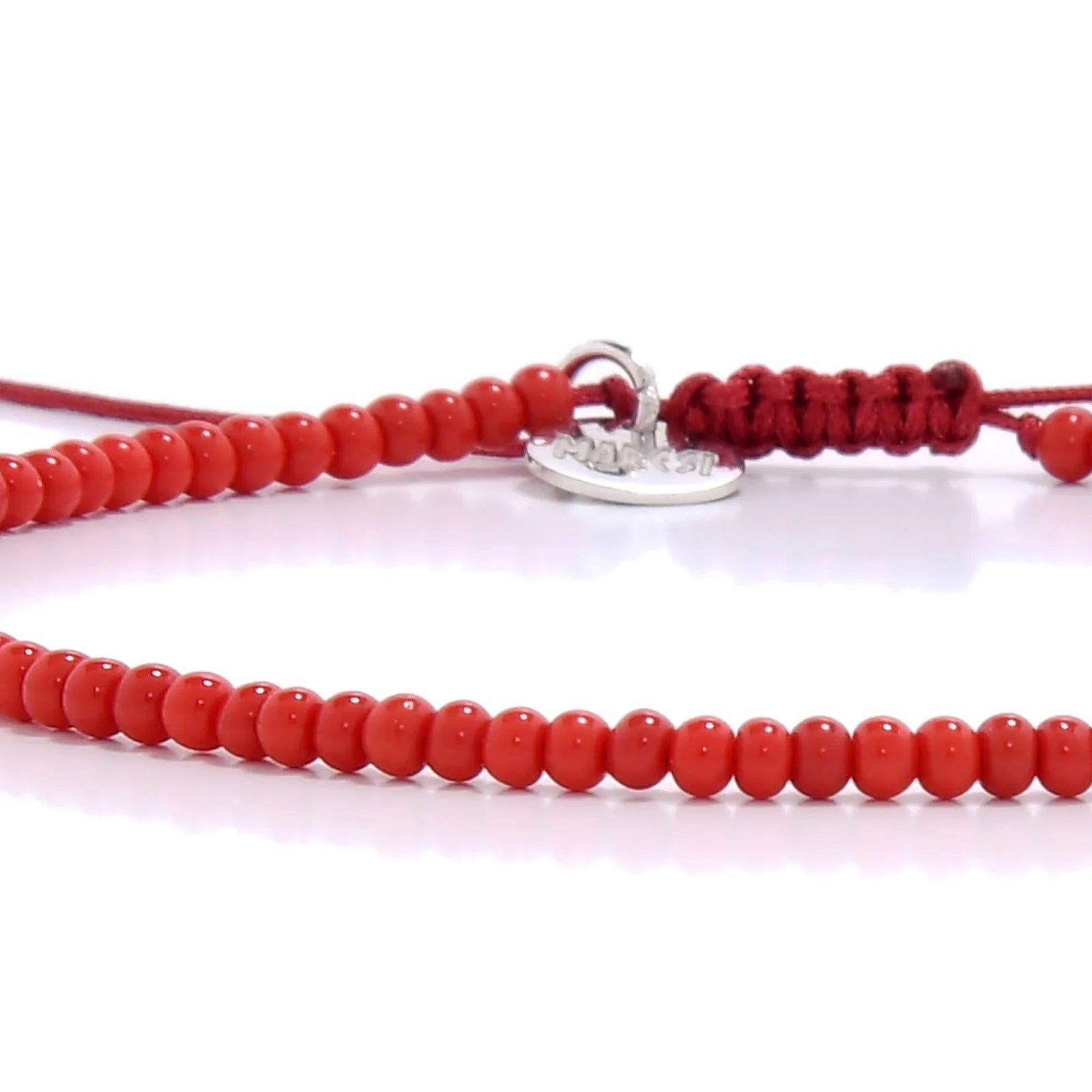Detailed view of Men Beaded Bracelets with red seed beads with silver charm, seed bead texture, and cord knot