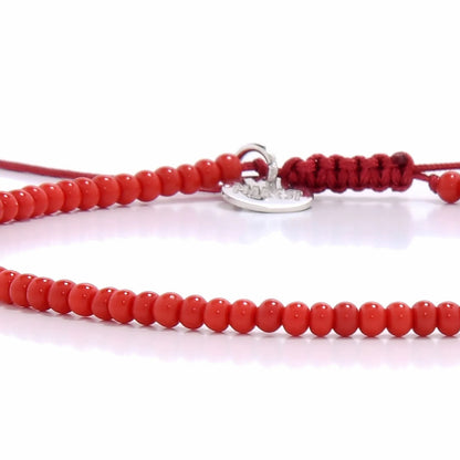 Detailed view of Men Beaded Bracelets with red seed beads with silver charm, seed bead texture, and cord knot