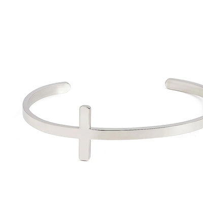 Close-up of men's cross bracelet showing raised cross centerpiece on a smooth polished cuff band
