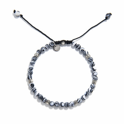 men’s malachite bracelet laid flat, showing circular pattern and woven cord clasp