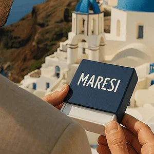 Men's beaded bracelets by Maresi Jewelry packaging with Santorini white buildings and blue domes in background