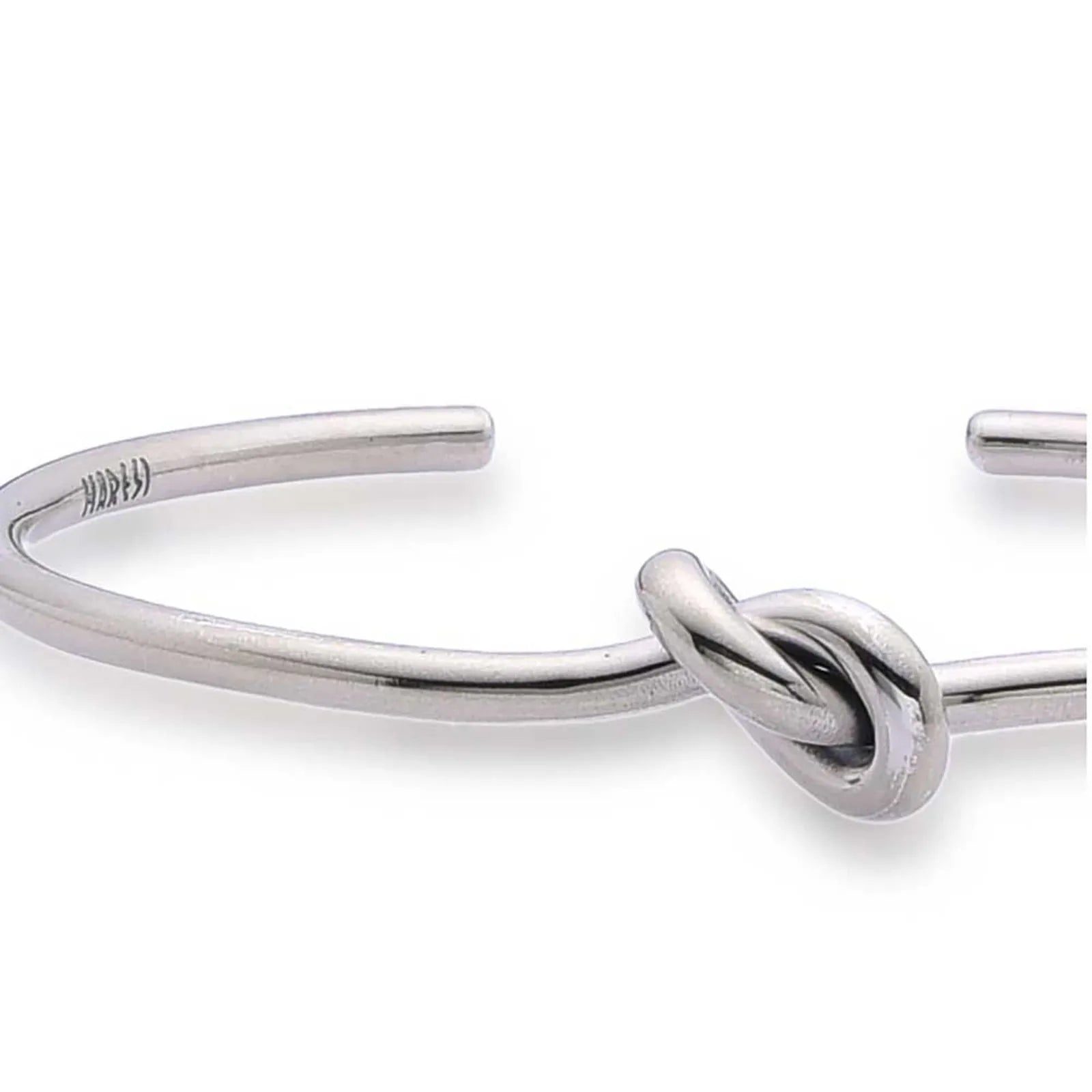Close-up of Mens Cuff Bracelets with smooth metal band, raised knot, and polished finish