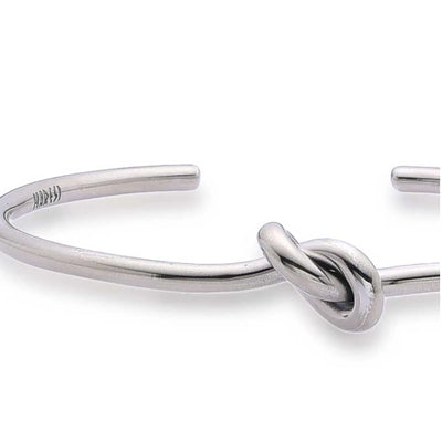 Close-up of Mens Cuff Bracelets with smooth metal band, raised knot, and polished finish