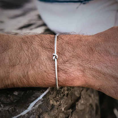 Lifestyle wrist view of Mens Cuff Bracelets with polished knot cuff worn outdoors