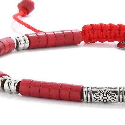 Detailed view of mens red bracelet with red clay beads with engraved silver spacers, Shamballa clay bead texture, and cord
