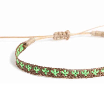 Close-up of mens rope bracelet showing brown woven band, green cactus pattern, and cord closure