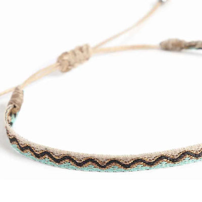 Close-up of Men's Rope Bracelets with cream woven band, black zigzag pattern, and turquoise edge