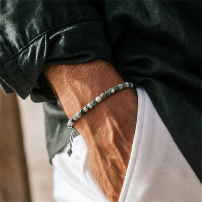 Moss Agate Jewelry worn on a wrist with a dark sleeve