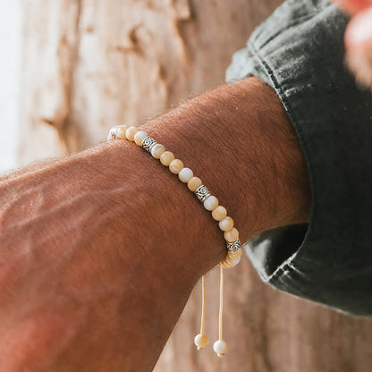 Mother of Pearl Bracelet worn on a wrist with beaded design and adjustable cord