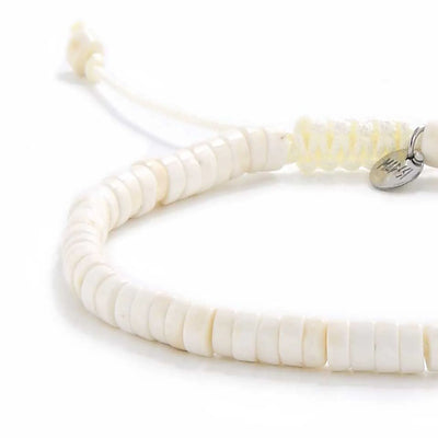Close-up of Off White Bracelet showing off white clay beads with blue accent bead, silver charm, and cord closure