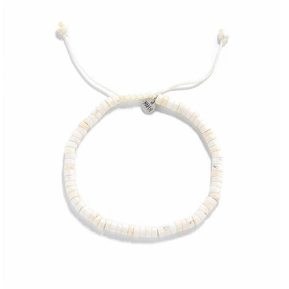 Off White Bracelet shown from above with off white clay beads with blue accent bead and round bracelet shape