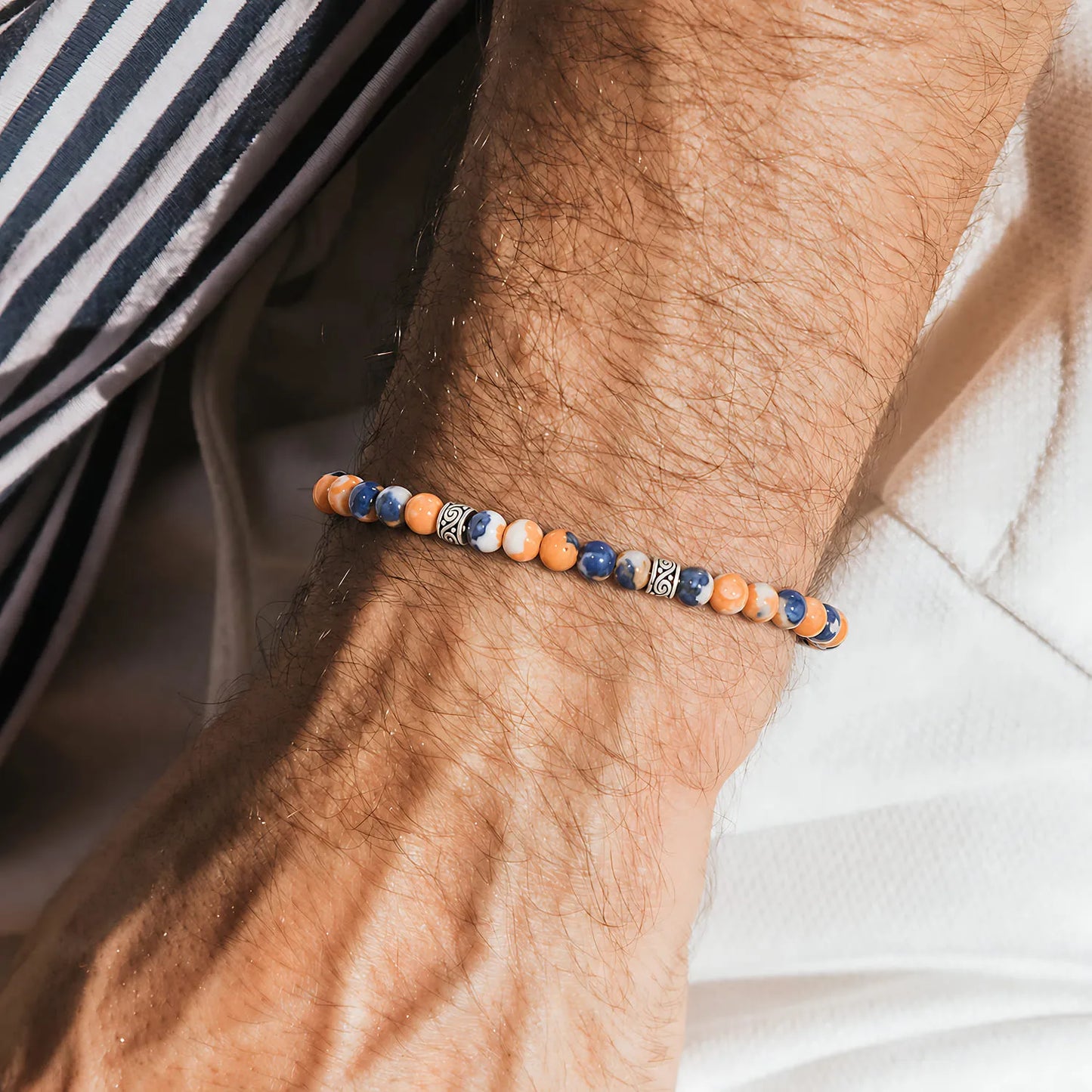 Orange Stone Bracelet worn on a wrist beside a striped shirt