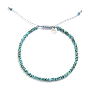 Full front view of beaded bracelet with turquoise picasso seed beads and sliding cord closure