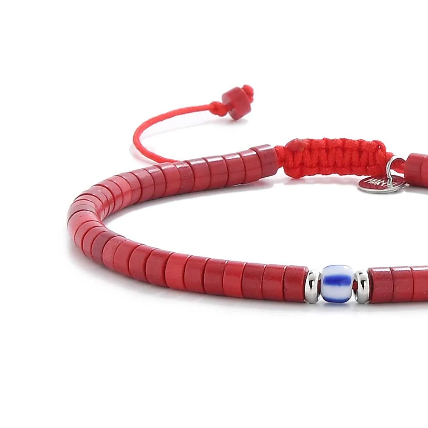 Close-up of red gemstone jewelry showing red clay beads with blue accent bead, silver charm, and cord closure