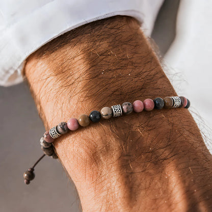 Rhodonite Crystal Bracelet worn on a wrist with a light sleeve