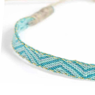 Detailed view of Rope Bracelet Mens texture with turquoise cord, chevron stitching, and gold detail