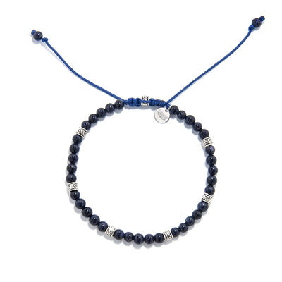 Sandstone Bracelet top view with round bead loop, blue drawcord ends, silver charm, and spacers