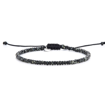 Front display of SCALA PICASSO seed bead bracelet with dark speckled seed beads on black string