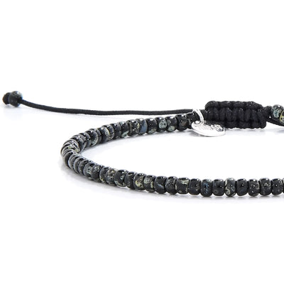 Close-up of Seed Bead Bracelets showing black and gray Picasso seed beads, silver charm, and cord closure