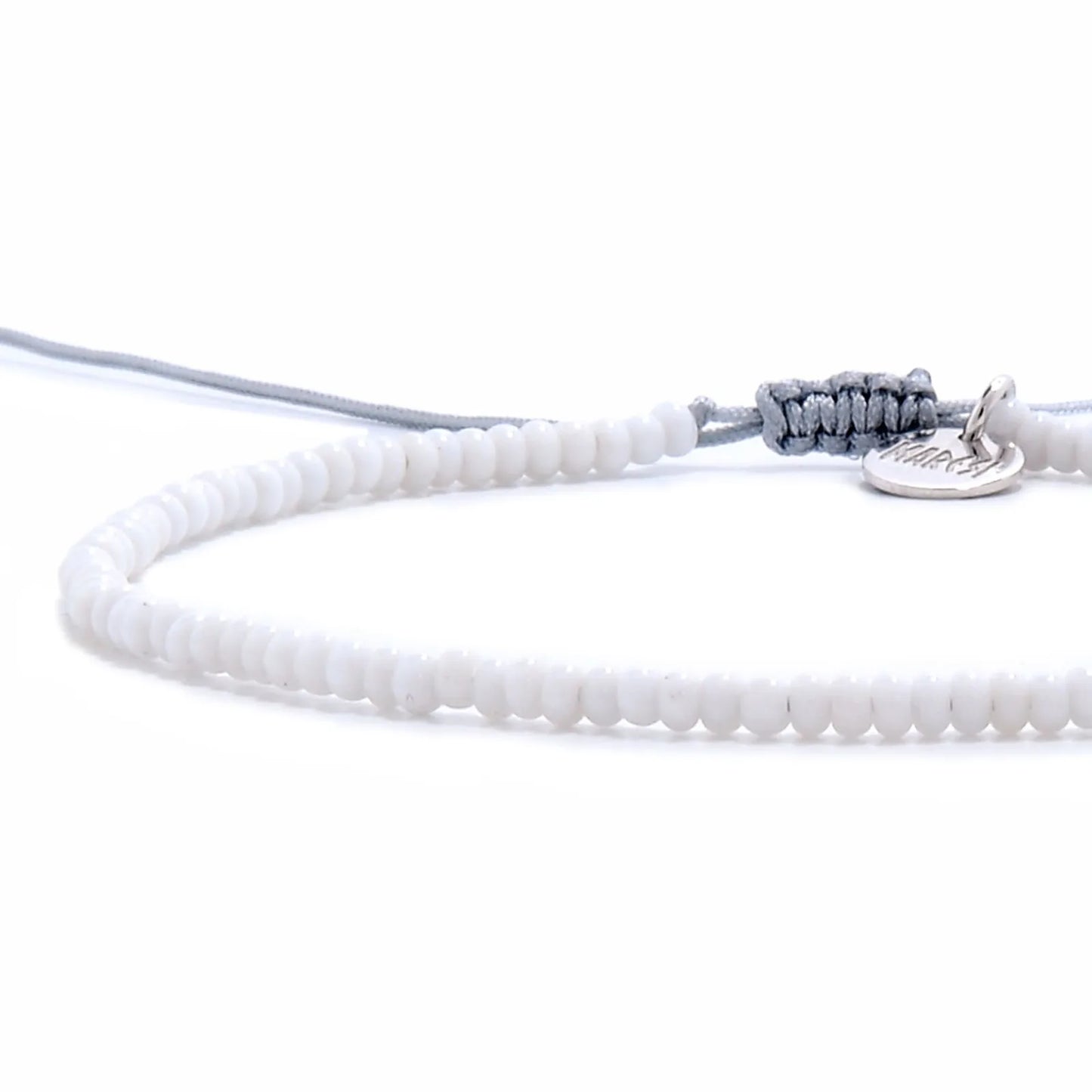 Close-up of Small Beaded Bracelets showing white seed beads with gray cord, silver charm, and cord closure